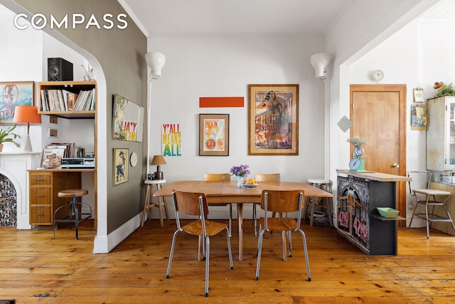 dining space with ornamental molding and hardwood / wood-style flooring