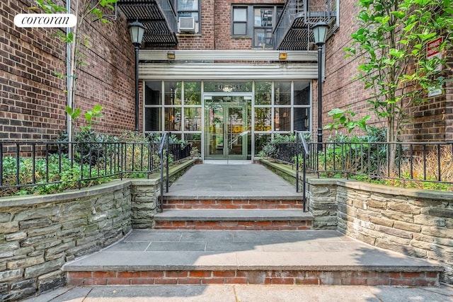 doorway to property with cooling unit, french doors, and brick siding