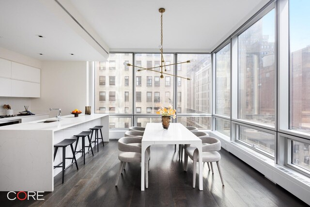 dining space featuring dark wood-type flooring and an inviting chandelier