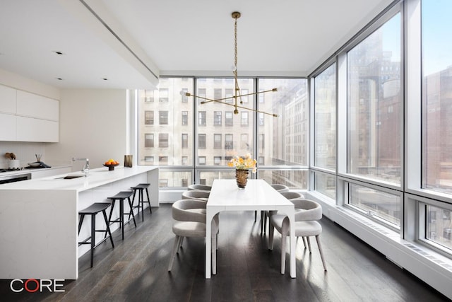 dining space featuring dark wood-type flooring and an inviting chandelier