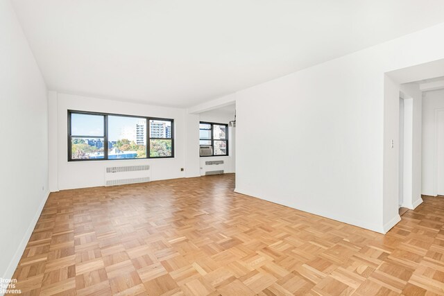 spare room with radiator and light parquet flooring