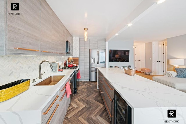 kitchen with stainless steel appliances, sink, beverage cooler, pendant lighting, and a center island