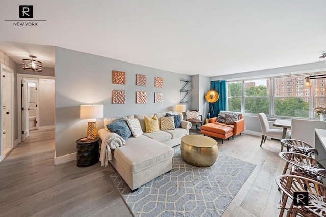 living room featuring wood-type flooring and a notable chandelier