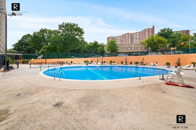 pool featuring fence and a patio