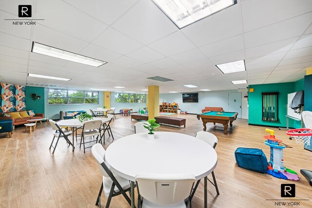 game room with a paneled ceiling, light wood-style flooring, and visible vents