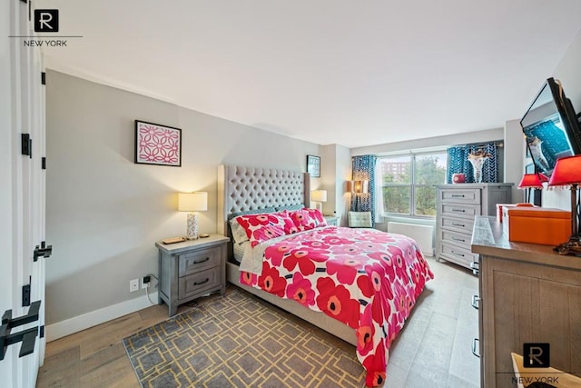 bedroom with baseboards and wood finished floors