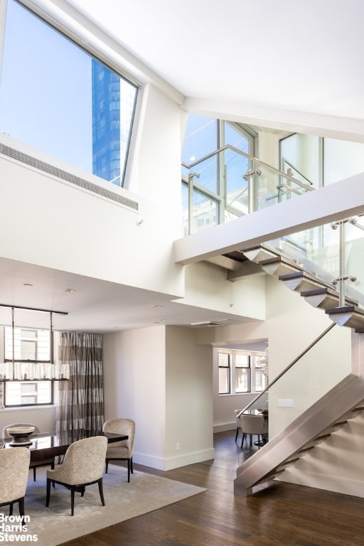 stairway featuring hardwood / wood-style flooring and a towering ceiling