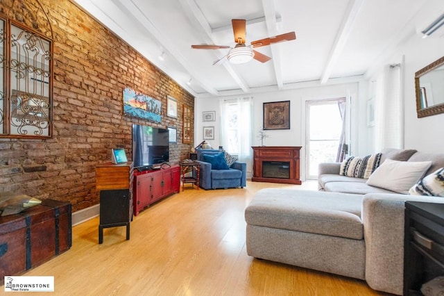 living room featuring a wall unit AC, ceiling fan, brick wall, wood-type flooring, and beam ceiling