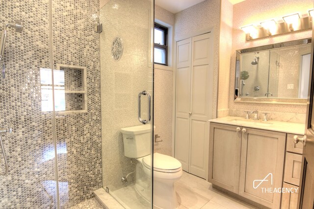 bathroom featuring a stall shower, tile patterned flooring, vanity, and toilet