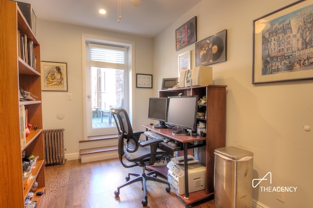 office featuring baseboards, radiator, and wood finished floors