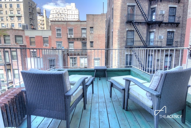 wooden terrace with a view of city and radiator heating unit