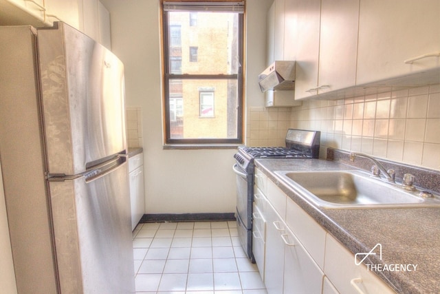 kitchen featuring backsplash, under cabinet range hood, white cabinets, stainless steel appliances, and a sink