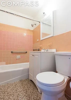 full bathroom with tiled shower / bath combo, vanity, and toilet