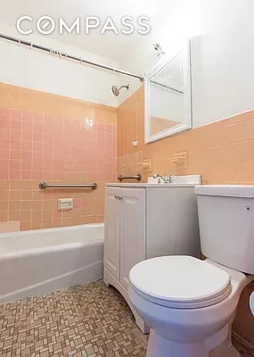 bathroom featuring vanity, toilet, and tub / shower combination