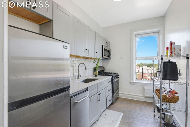 kitchen featuring sink, gray cabinets, stainless steel appliances, and a healthy amount of sunlight