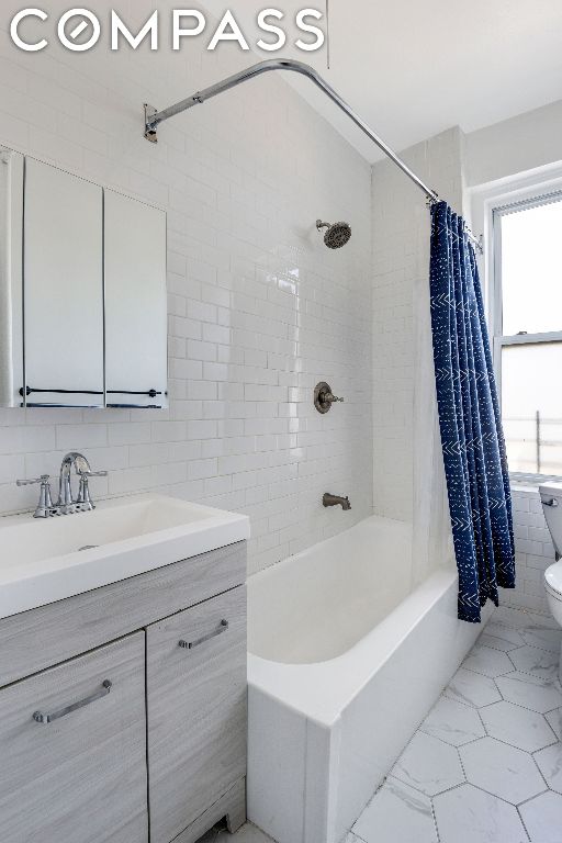 full bathroom featuring shower / tub combo with curtain, tile walls, toilet, and a healthy amount of sunlight