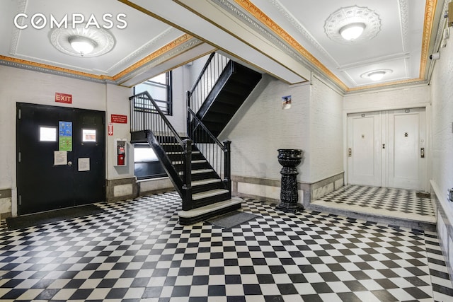 foyer with tile patterned floors, stairs, and crown molding