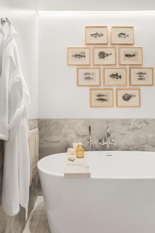 bathroom with tile patterned flooring, tile walls, and a tub