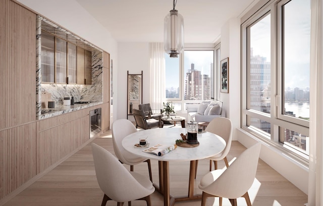 dining space with a view of city, wine cooler, and light wood finished floors