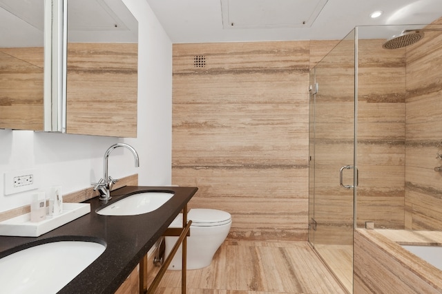 bathroom featuring vanity, toilet, and a shower with shower door