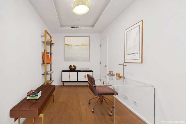 office featuring a tray ceiling and hardwood / wood-style flooring