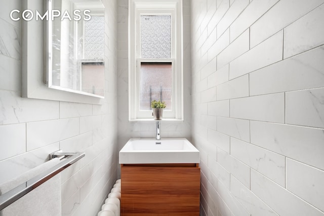bathroom with tile walls, radiator, and vanity