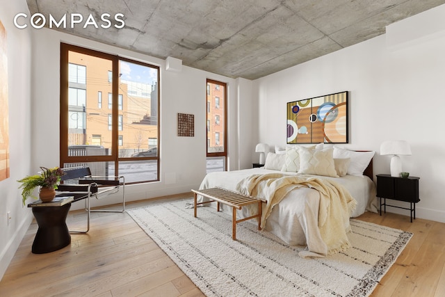 bedroom with wood-type flooring and baseboards