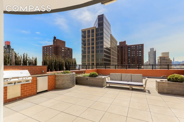 view of patio / terrace featuring a city view, an outdoor kitchen, an outdoor hangout area, and area for grilling