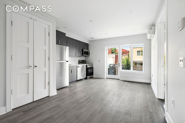 kitchen with decorative backsplash, wood finished floors, dark cabinets, stainless steel appliances, and light countertops