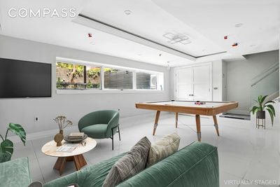 game room featuring plenty of natural light, a raised ceiling, and baseboards