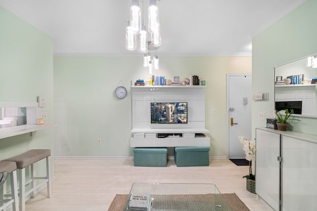 interior space featuring ornamental molding, light wood-type flooring, an inviting chandelier, and baseboards