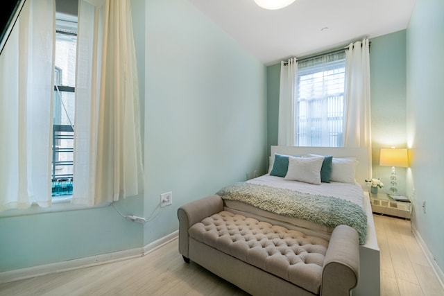 bedroom featuring baseboards, baseboard heating, and wood finished floors