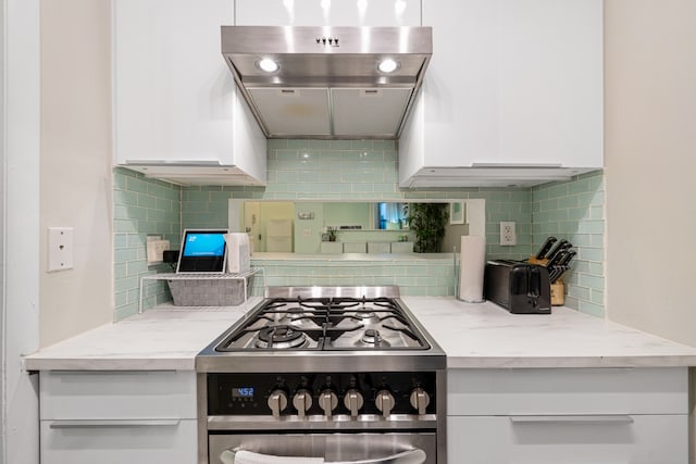 108 W 114th St Unit 4B, New York City, NY 10026 - kitchen featuring exhaust hood, white cabinetry, stainless steel range with gas cooktop, and backsplash