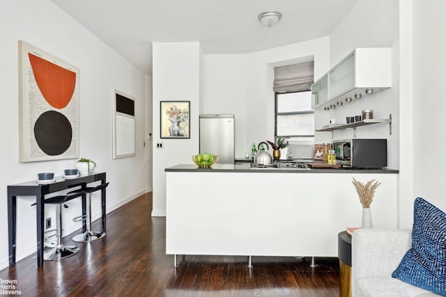 kitchen with white cabinetry, dark hardwood / wood-style floors, and appliances with stainless steel finishes