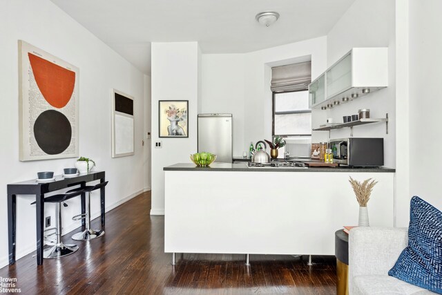 kitchen featuring white cabinetry, stainless steel appliances, and dark hardwood / wood-style floors