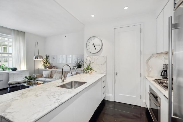 kitchen with white cabinetry, kitchen peninsula, and light stone countertops