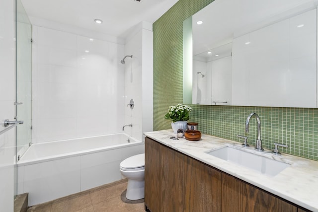 bathroom featuring tile patterned floors, toilet, tasteful backsplash, bathing tub / shower combination, and vanity