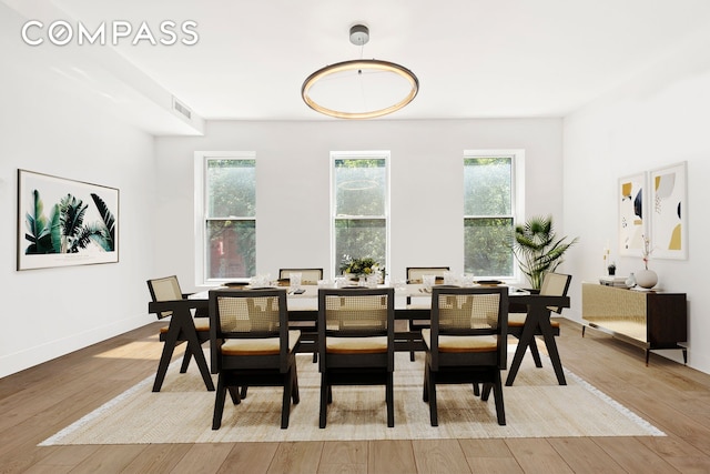 dining space featuring hardwood / wood-style floors, baseboards, and visible vents