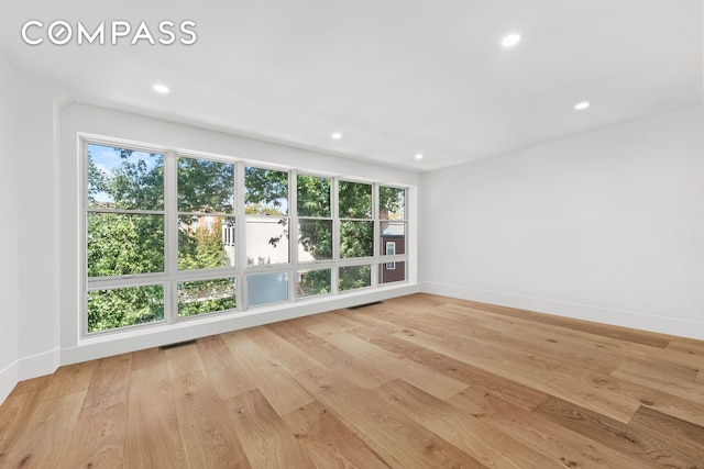 unfurnished room with recessed lighting, visible vents, baseboards, and wood finished floors