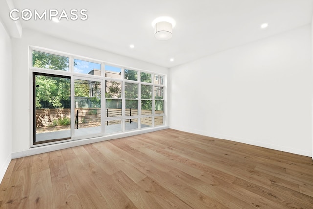 unfurnished room with recessed lighting, baseboards, and wood finished floors