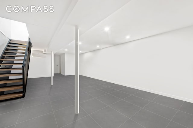 finished basement featuring stairs, dark tile patterned floors, recessed lighting, and baseboards