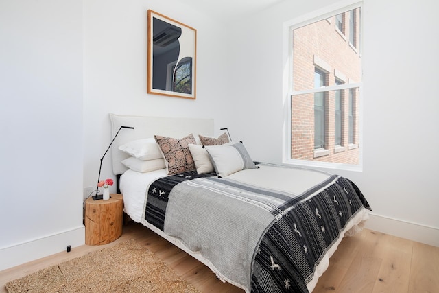 bedroom featuring wood finished floors and baseboards