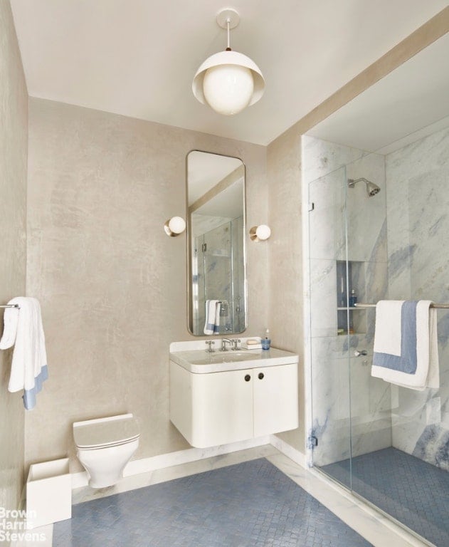 bathroom featuring vanity, tile patterned flooring, toilet, and walk in shower