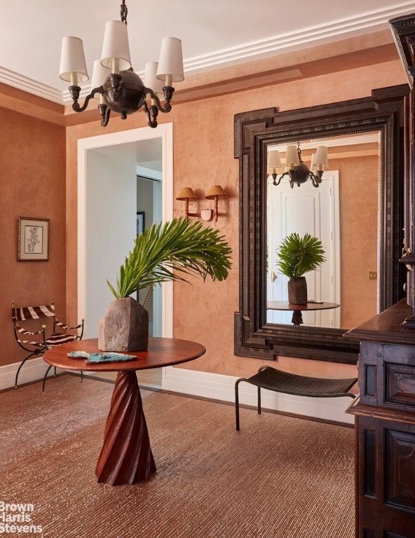 sitting room with a notable chandelier and ornamental molding