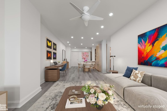 living room with light hardwood / wood-style flooring and ceiling fan