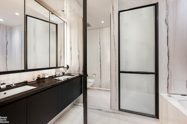 full bath with a sink, tile walls, toilet, and an enclosed shower