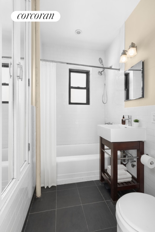 full bathroom with tile walls, shower / tub combo, tile patterned flooring, vanity, and toilet