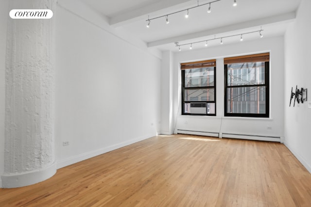 unfurnished room with beamed ceiling, rail lighting, cooling unit, a baseboard heating unit, and light hardwood / wood-style flooring