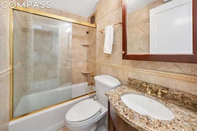 full bathroom featuring toilet, tasteful backsplash, combined bath / shower with glass door, tile walls, and vanity