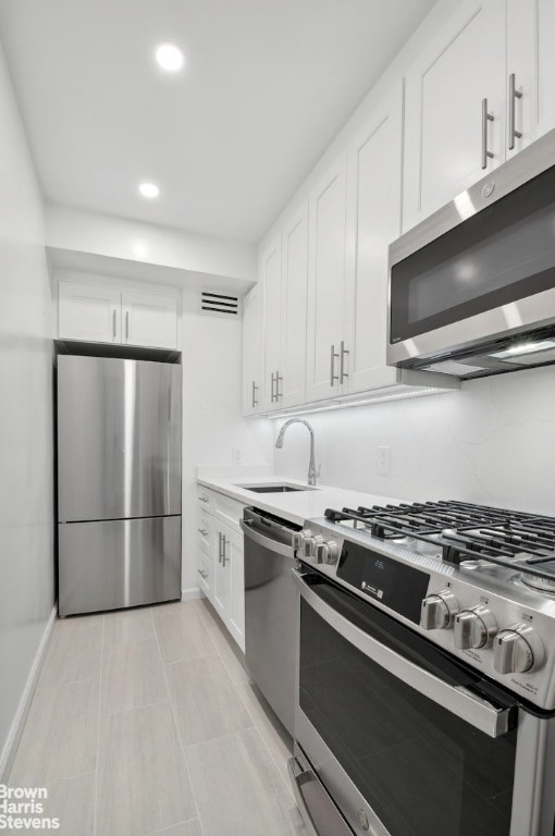 kitchen featuring white cabinets, appliances with stainless steel finishes, and sink